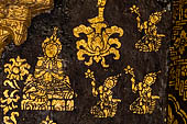 Wat Xieng Thong temple in Luang Prabang, Laos. Detail of the  intricate gold stencilling on black lacquer that decorate the walls of the sim. 